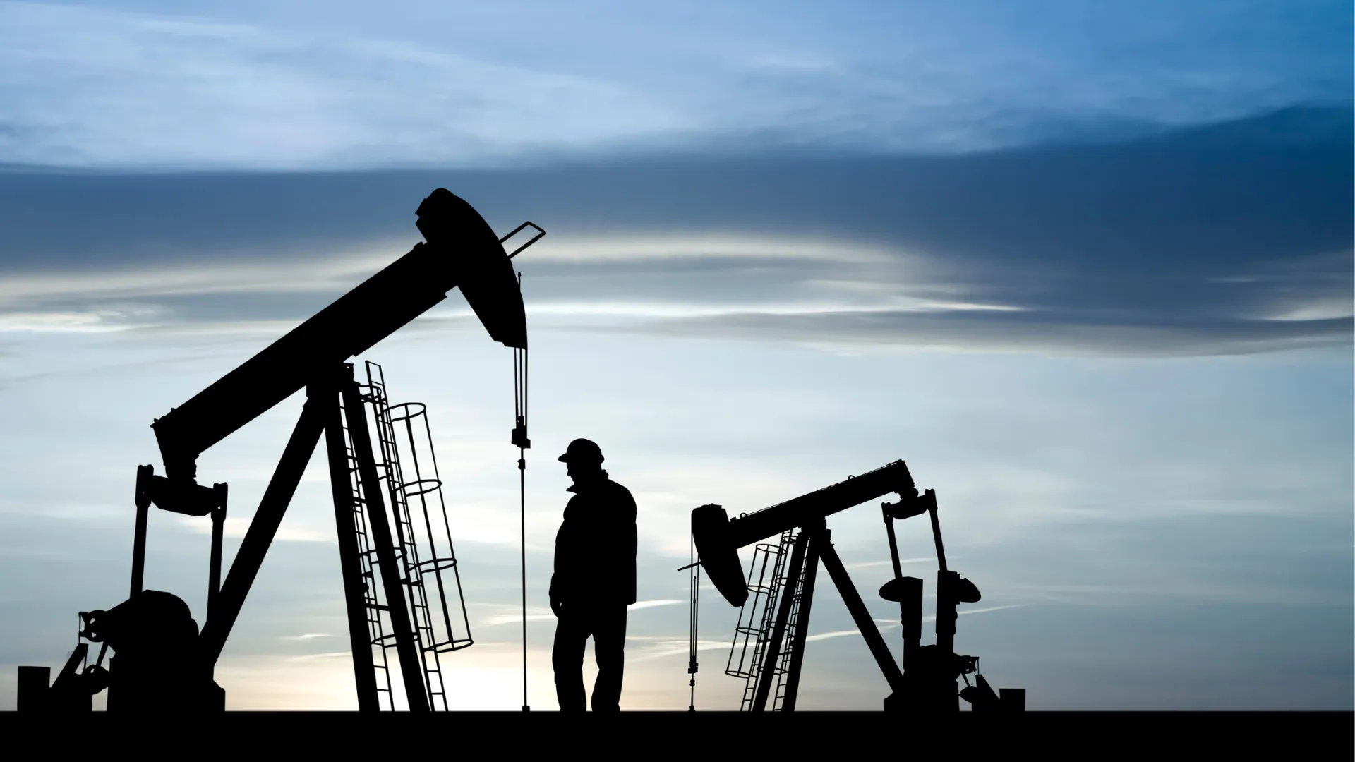 Silhouette of oil derrick and a person